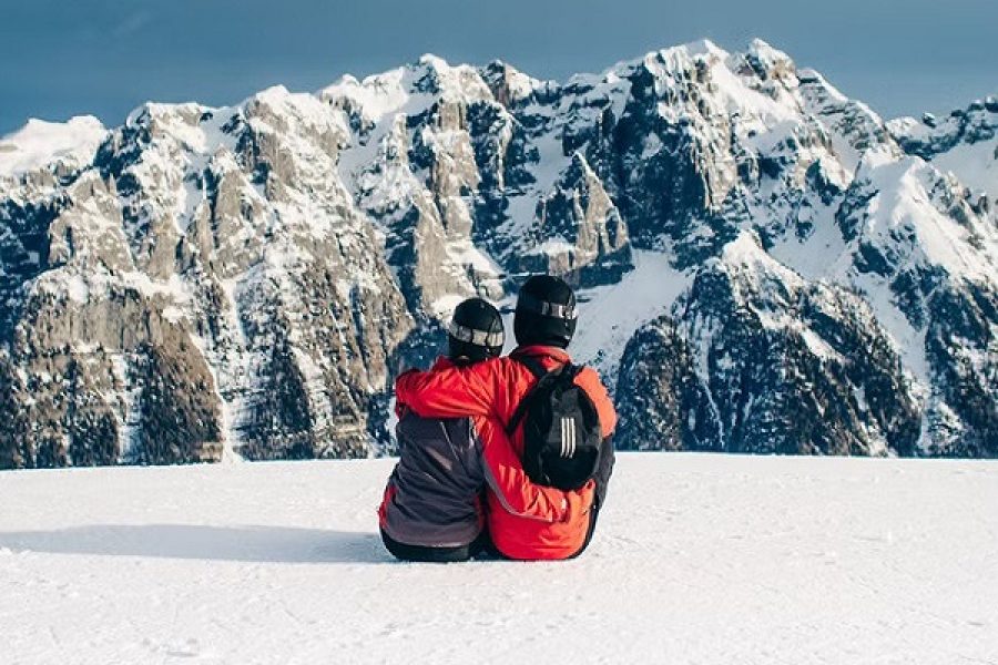 Romantic couple in a shikara on Dal Lake in Kashmir, surrounded by majestic mountains and lush greenery